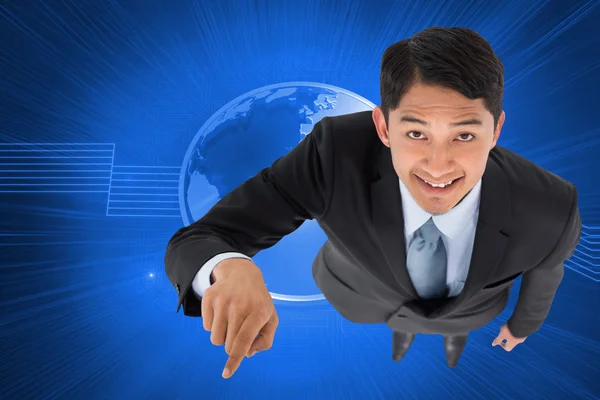 Composite image of smiling asian businessman pointing — Stock Photo, Image