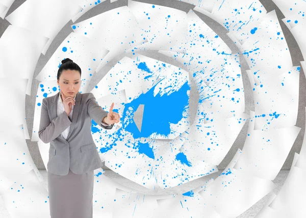 Composite image of unsmiling thinking asian businesswoman pointing — Stock Photo, Image