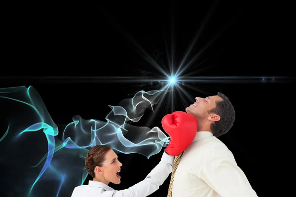 Empresaria golpeando a un empresario con guantes de boxeo — Foto de Stock