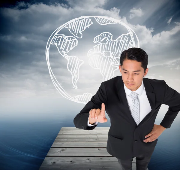 Composite image of unsmiling asian businessman pointing — Stock Photo, Image