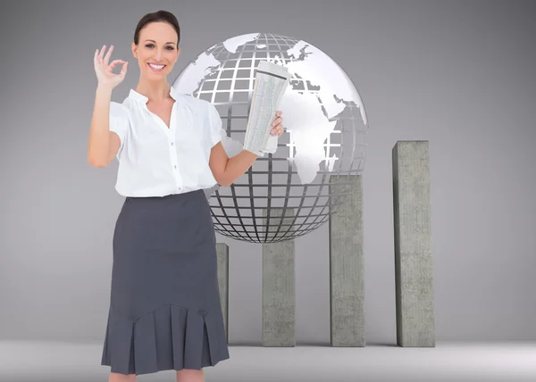 Businesswoman making gesture while holding newspaper — Stock Photo, Image