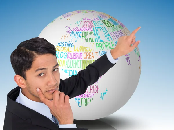 Composite image of thoughtful asian businessman pointing — Stock Photo, Image