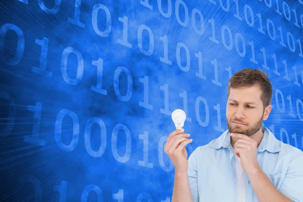 Sceptical model holding a bulb — Stock Photo, Image