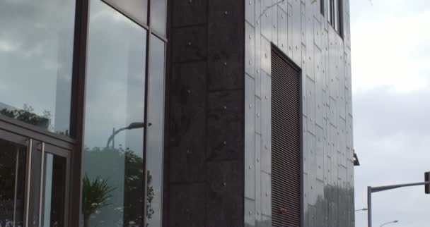 Baixo ângulo de tiro de um edifício de escritório cinza alto — Vídeo de Stock