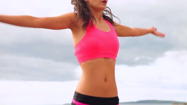 Brune paisible pratiquant le yoga sur la plage — Video