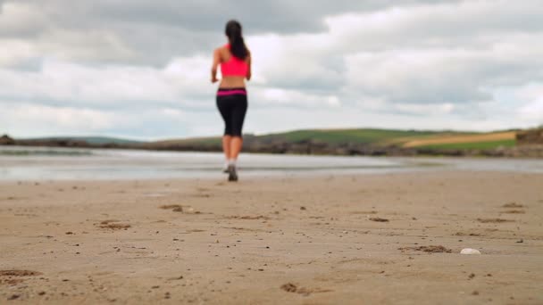 Morena atlética corriendo en la playa — Vídeo de stock