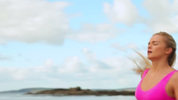 Fit blonde jogging on the beach — Stock Video