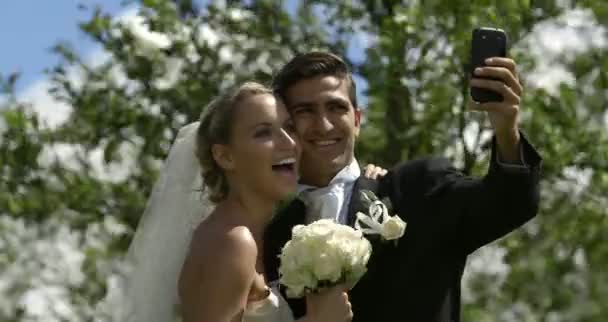 Νύφη και γαμπρός λαμβάνοντας ένα selfie έξω από — Αρχείο Βίντεο