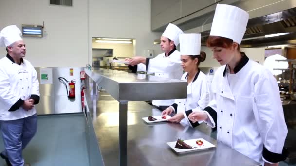 Jefe de cocina inspeccionando sus estudiantes postres — Vídeos de Stock