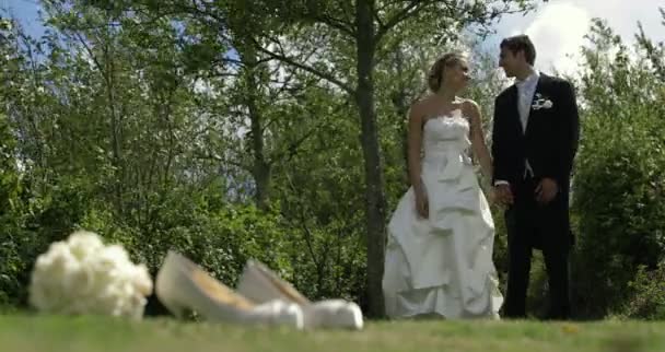 Жених и невеста стоят на улице в солнечный день — стоковое видео