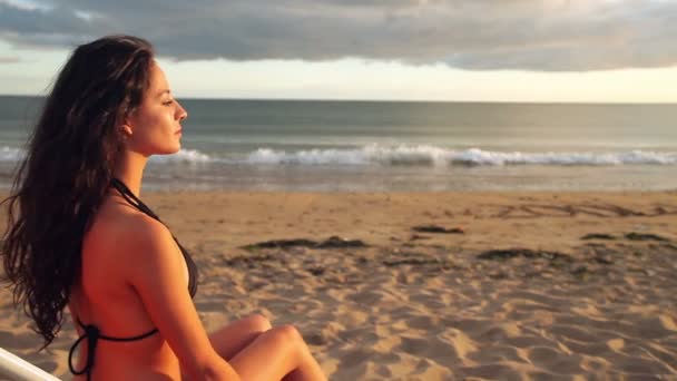 Calma morena sentada em uma cadeira de praia relaxante — Vídeo de Stock