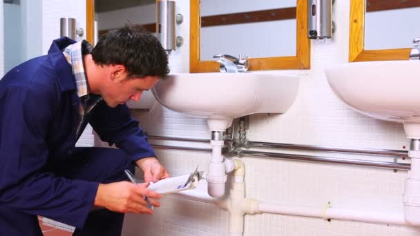 Handsome plumber looking at sink holding clipboard — Stock Footage Handsome plumber looking at sink holding clipboard Royalty Free Stock Footage