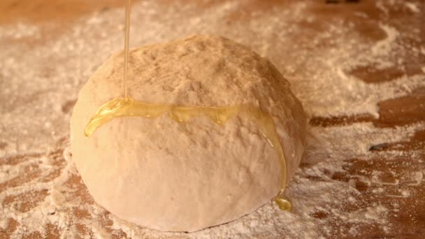 Azeite sendo derramado sobre a massa de farinha em uma mesa farinhenta — Vídeo de Stock