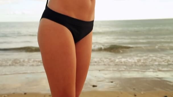 Brunett stående på stranden innehar en blå halsduk — Stockvideo