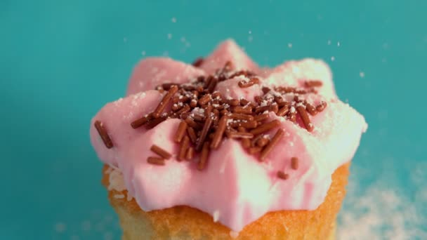 Ζάχαρη άχνη που κοσκινίζονται σε ροζ παγωμένος cupcake — Αρχείο Βίντεο