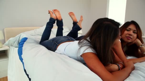 Sisters lying on bed chatting — Stock Video