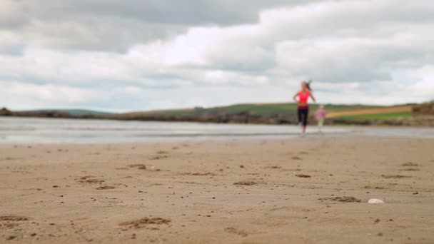 Ajuste morena correndo na praia — Vídeo de Stock