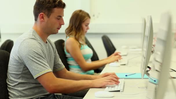 Twee gerichte studenten werken in computerlokaal — Stockvideo