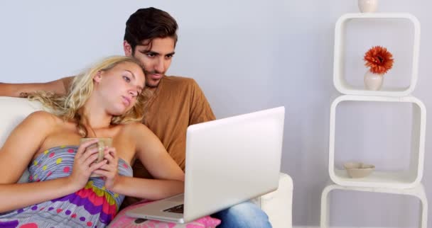 Bored couple watching the laptop on the couch — Stock Video