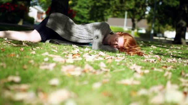 Мирно дремлющая рыжая, лежащая на зеленом газоне — стоковое видео