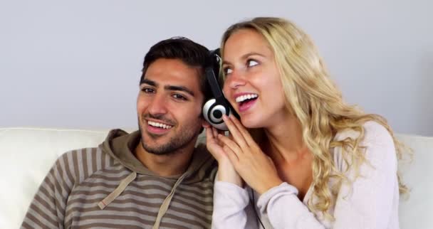 Cute couple listening to music together on the couch — Stock Video