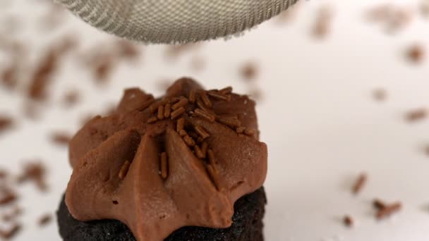 Zucchero freddo setacciato su un cupcake al cioccolato — Video Stock