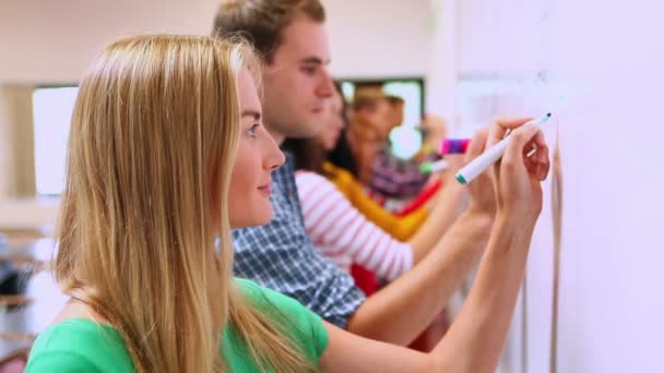 Fila de estudiantes escribiendo en pizarra blanca en el aula — Vídeos de Stock