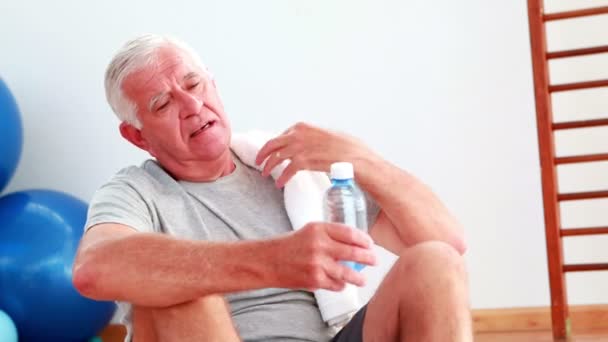 Senior trinkt Wasser sitzend auf dem Boden — Stockvideo