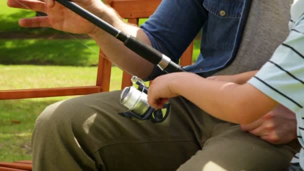 Babası küçük oğlu bir bankta balık tutmayı öğretmek — Stok video