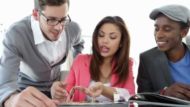 Equipo de diseño de moda trabajando juntos en la mesa mirando la joyería — Vídeos de Stock