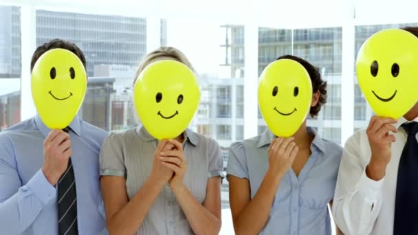 Zakelijke team houden smiley gezicht ballonnen — Stockvideo