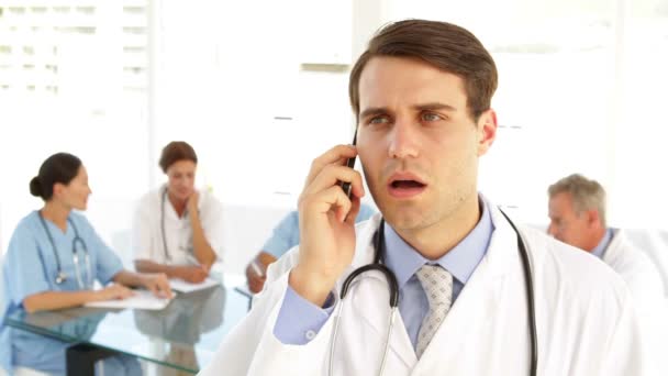 Красивий лікар розмовляє по телефону — стокове відео