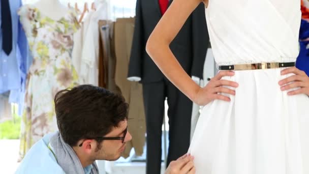 Designer adjusting hemline of dress on model — Stock Video