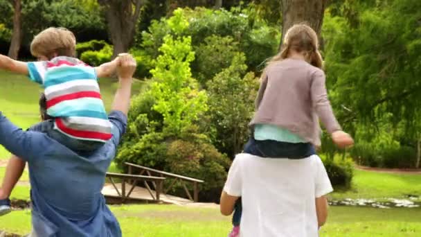 Mutlu bir aile birlikte parkta oynarken — Stok video