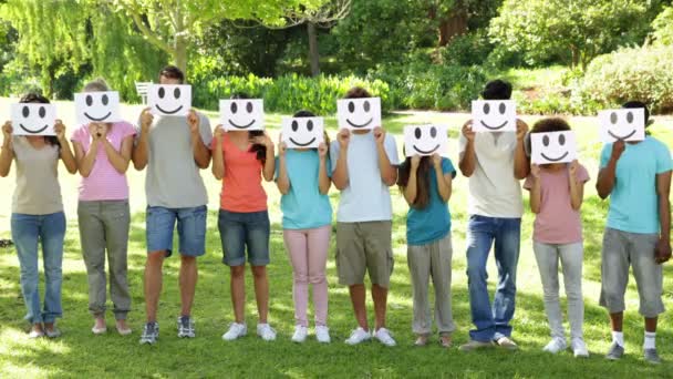Groupe de jeunes amis occasionnels tenant des visages souriants sur leurs visages — Video