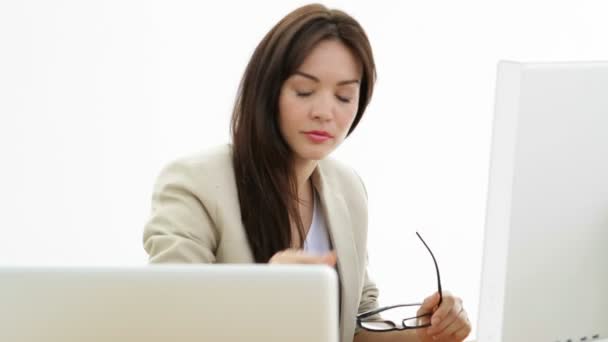 Vrouw werken bij haar bureau met behulp van laptop en computer — Stockvideo