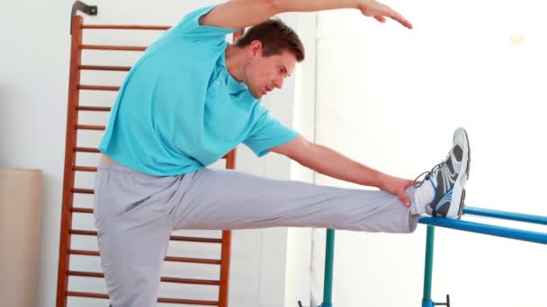 Hombre flexible estirando su pierna — Vídeo de stock