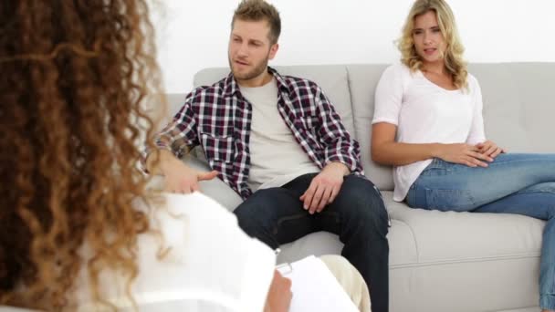 Discutiendo pareja joven sentada en el sofá — Vídeo de stock