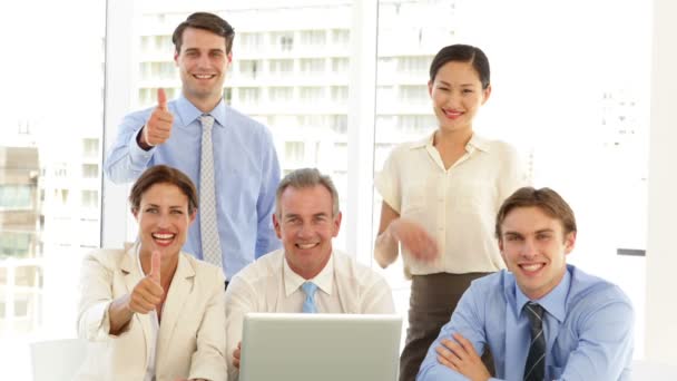 Equipo de negocios feliz posando frente a la computadora portátil — Vídeo de stock