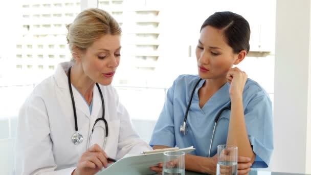 Doctor and nurse going over a file — Stock Video