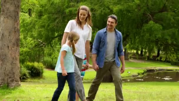 Glückliche Familie beim gemeinsamen Spaziergang im Park — Stockvideo