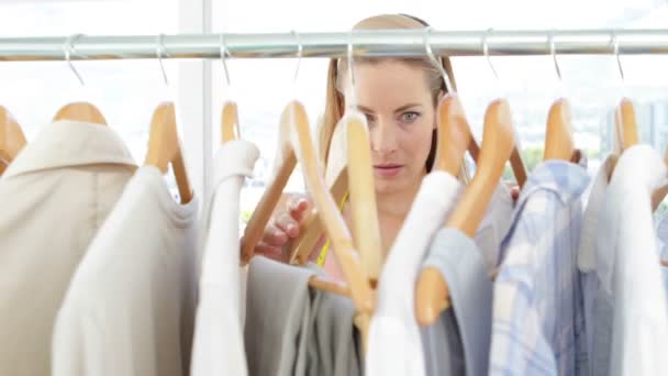 Designer de moda olhando para roupas no trilho — Vídeo de Stock