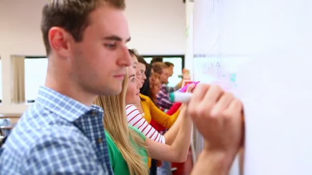 Rad fokuserade elever skriva på Whiteboard-tavlan i klassrummet — Stockvideo