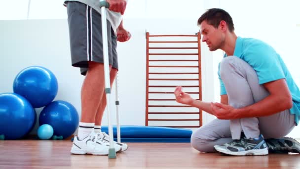 Physiotherapist helping patient walk with crutches — Stock Video