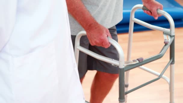 Médico sorridente conversando com o paciente usando zimmer frame — Vídeo de Stock