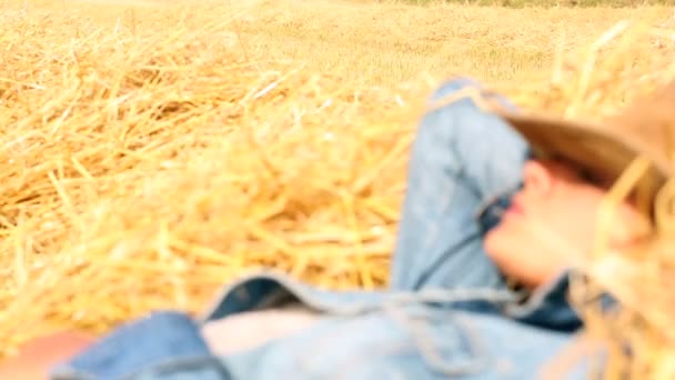 Fredlig kvinna iklädd cowboyhatt liggande i hö — Stockvideo