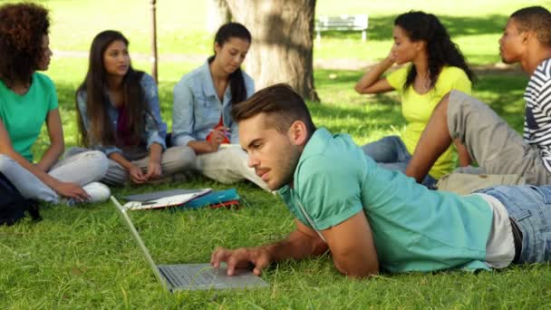 Estudiante usando su portátil delante de sus amigos — Vídeo de stock