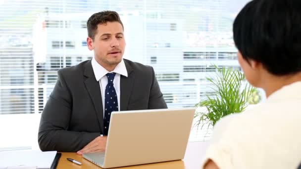 Geschäftsmann mit Laptop interviewt Frau am Schreibtisch — Stockvideo