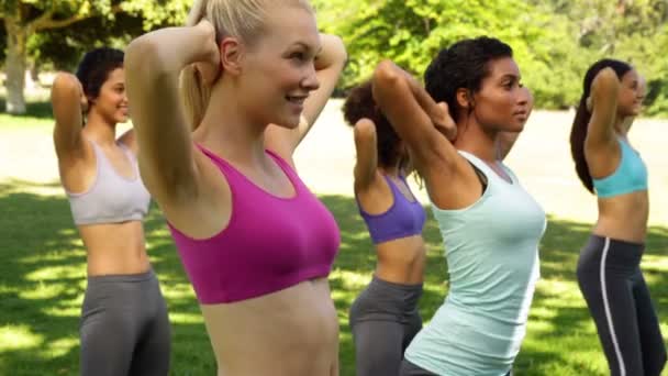 Fitness class doing squats in unison — Stock Video