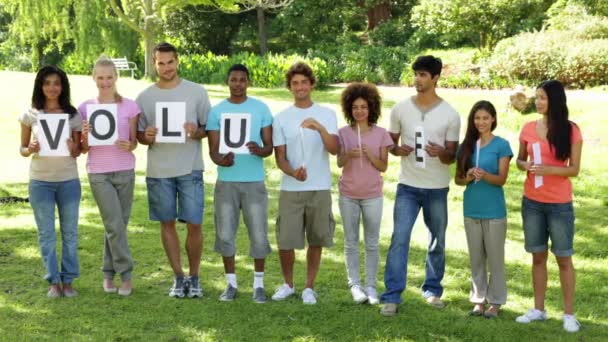 Friends holding letters spelling volunteer — Stock Video